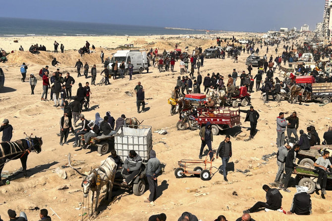 2024年2月25日、ガザ市の海辺で人道援助物資を待つパレスチナ人ら。（AP）