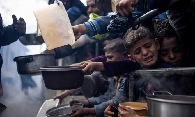 2月初め、ガザ地区のラファで無料の食事を求めて並ぶパレスチナ人。(AP)