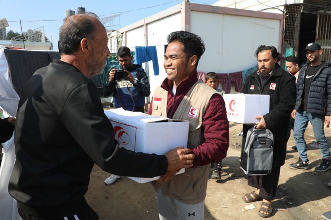 インドネシアのNGO、医療緊急救援委員会(MER-C)のボランティアがパレスチナ人に食料を手渡す。(MER-C)