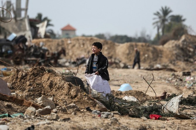 マガジキャンプの瓦礫の中に立ち、涙を流すパレスチナ人の少年。（AFP）