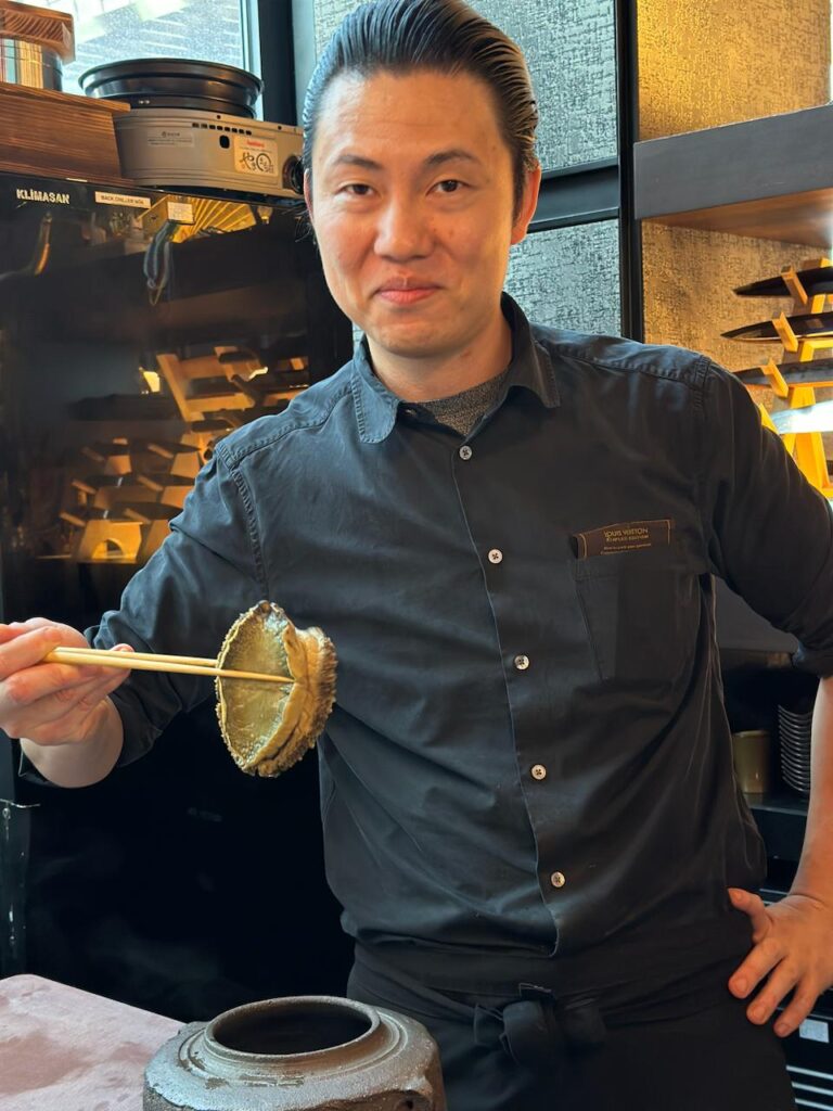シェフ・タカと彼の名物料理の蒸しアワビ。(ANJ)