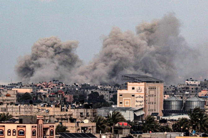 イスラエル軍による爆撃後、遠くハーン・ユーニスの建物の上で煙が立ち上る。2024年2月5日撮影（ファイル/AFP）