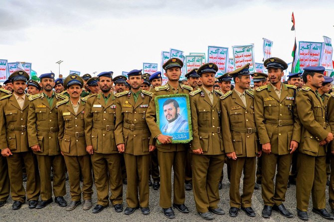 2024年2月16日、サヌアで人々が行進する中、武装組織フーシ派の指導者アブドルマリク・アル・フーシ氏の肖像を掲げるフーシ派系治安部隊のメンバー。（AFP）