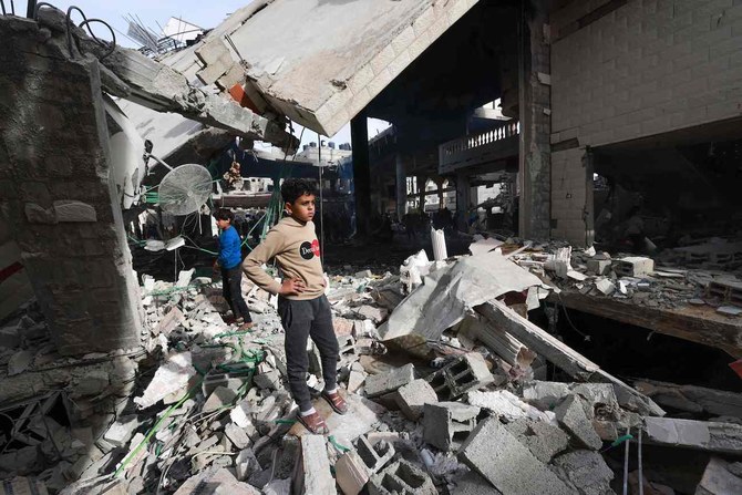 2024年2月12日、ガザ地区南部のラファで、イスラエル軍の空爆を受けたモスクの瓦礫の中の被害状況を確認する人々。（AFP）