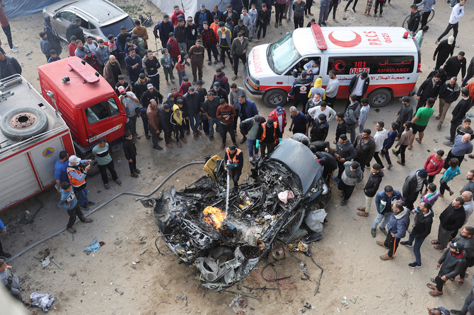 イスラエルとパレスチナのイスラム原理主義集団ハマスの間で戦闘が続くなか、ガザ地区南部のラファで、イスラエルの空爆で破壊された車を調べるパレスチナ人たち。2024年2月10日。（Reuters）