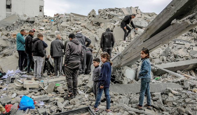 2024年3月16日、イスラエルとパレスチナ・ハマスの戦闘が続く中、ガザ市のリマル地区で、前夜のイスラエル軍の攻撃で破壊された建物の瓦礫を調べるパレスチナ人。(AFP=時事)