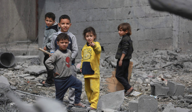 ガザ地区中央部で、イスラエル軍の爆撃を受けた建物の残骸を調べるパレスチナの子どもたち。(AFP＝時事）