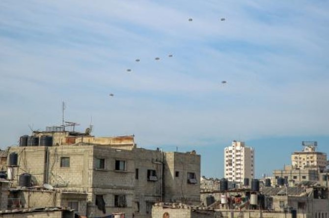 イスラエルは意図的にガザの住民を飢えさせており、戦争犯罪とジェノサイドの責任を問われるべきだと、国連当局者は先に述べた。空から投下された支援物資に向かって走るパレスチナ人。(AFP＝時事）