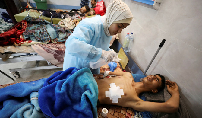 イスラエルとハマスの紛争が継続する最中、アルシファ病院のベッドに横たわるパレスチナ人男性。ガザ地区の保健当局の職員によると、この男性は、援助物資を待っている間にイスラエル軍から銃撃を受けたのだという。ガザ市。2024年3月1日。(ロイター通信)