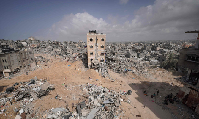 イスラエルとハマスの対立が続く中、2024年3月6日、ガザ地区南部のハーン・ユーニスで、イスラエル軍の砲撃によって破壊された家屋のがれきの中に立つパレスチナ人。(AFP）