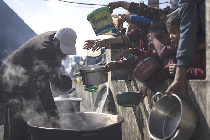 写真上：2024年2月16日、ガザ地区のラファで無料食事を求めて並ぶパレスチナ人。(AP)