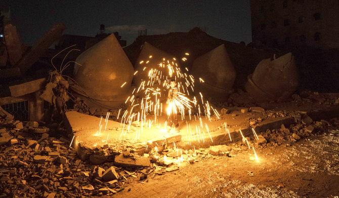 2024年3月10日日曜日、ガザ地区のラファで、イスラエルの空爆によって破壊されたモスクの隣で、イスラム教の聖月ラマダンの開始を祝って花火で遊ぶパレスチナの少年。(AP)