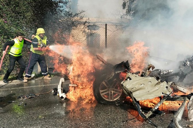 国境を越えた緊張が続く中、イスラエルとの国境に近いレバノン南部のナクーラ地区で、イスラエルの無人機による攻撃で炎上した車を放水する消防隊員。( AFP)