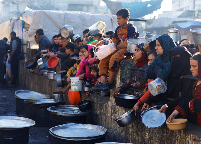 2024年3月13日、イスラム教の聖なる断食月ラマダンの間、ラファで食料を受け取るのを待つパレスチナ人。(ロイター)