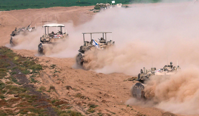 2024年2月26日、イスラエルとパレスチナ過激派組織ハマスとの戦闘が続く中、ガザ地区との国境付近でイスラエルから撮影された写真は、ガザから移動するイスラエルの装甲兵員輸送車。(AFP）
