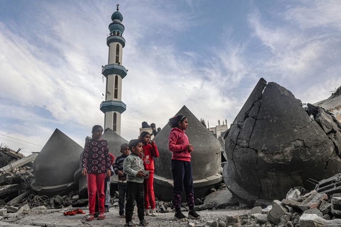 2024年3月17日、イスラエルとパレスチナ武装組織ハマスとの戦闘が続く中、ガザ地区南部のラファで、イスラエル軍の砲撃で破壊されたアル・ファルク・モスクのがれきの横に立つ子どもたち。(AFP＝時事）