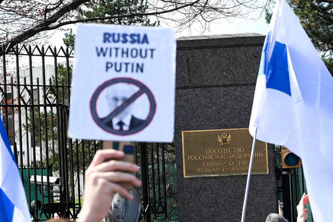 2024年3月17日、ワシントンD.C.のロシア大使館前で、有権者が列を作る中、反プーチン集会に参加する人々。(AFP＝時事）