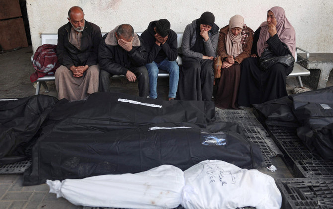 イスラエルと過激派組織ハマスの対立が続く中、2024年3月25日、ガザ地区南部ラファのアルナジャール病院で、イスラエル軍の砲撃で一夜にして死亡した親族の覆われた遺体を悼むパレスチナ人。(AFP＝時事）