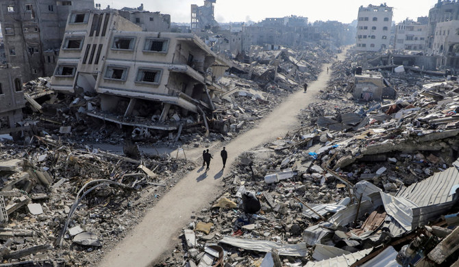 ガザ地区北部のジャバリア難民キャンプで、イスラエルとハマスの対立が続く中、破壊された家屋の前を歩くパレスチナ人（2024年2月22日撮影）。(REUTERS)