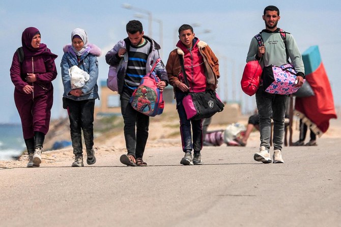 2024年3月25日、ガザ市から避難し、海岸沿いの道路を歩く避難民。(AFP＝時事）