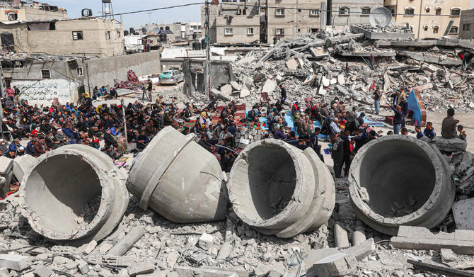 イスラエルの空爆で破壊されたラファ市のアル・ファルク・モスクの残骸の前で、金曜正午の礼拝に参加するパレスチナ人たち。