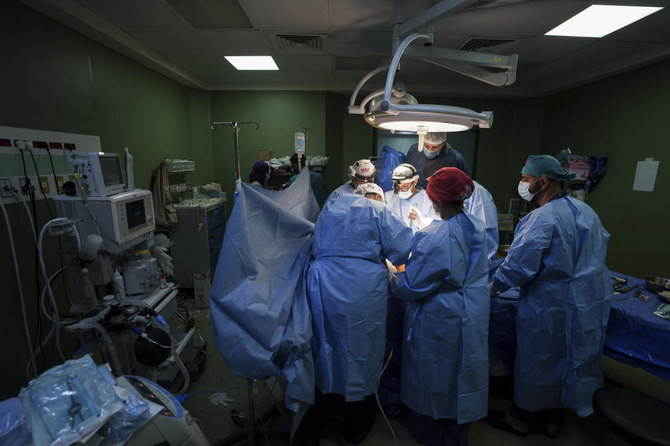 2024年3月17日、ガザ地区中部のデイル・アル・バラにあるアル・アクサ殉教者病院で、患者に手術を施す医師たち。(AP)