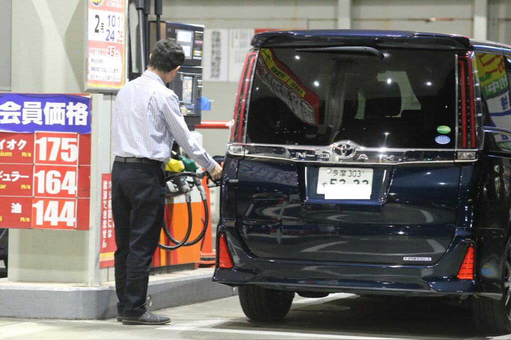 東京のガソリンスタンドで車にガソリンを入れる男性。(ANJ)