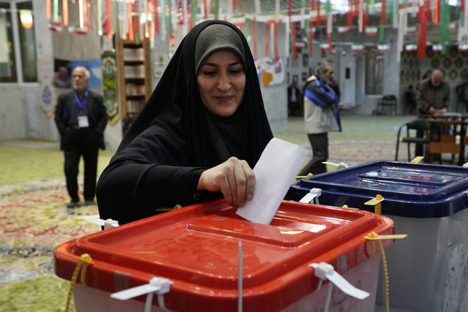 2024年3月1日、テヘランの投票所で、国会議員選挙と専門家会議選挙の投票用紙に記入する有権者。（AP）