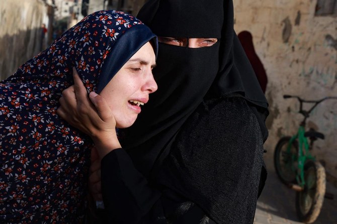 2024年3月3日、イスラエル軍の空爆で一夜にして死亡した双子の赤ちゃんナエムとウィッサムの母親ラニア・アブ・アンザさん(左)は、ラファでの埋葬を前に、その死を悼む。(ファイル/AFP)