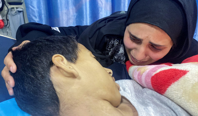 2024年3月30日、イスラエルとハマスの紛争が続くガザ地区北部のカマル・アドワン病院で、母親とともにアル・シファ病院から避難していた肝炎患者のパレスチナ人少年カラム・カダダの母親、息子の遺体に付き添う。(REUTERS)