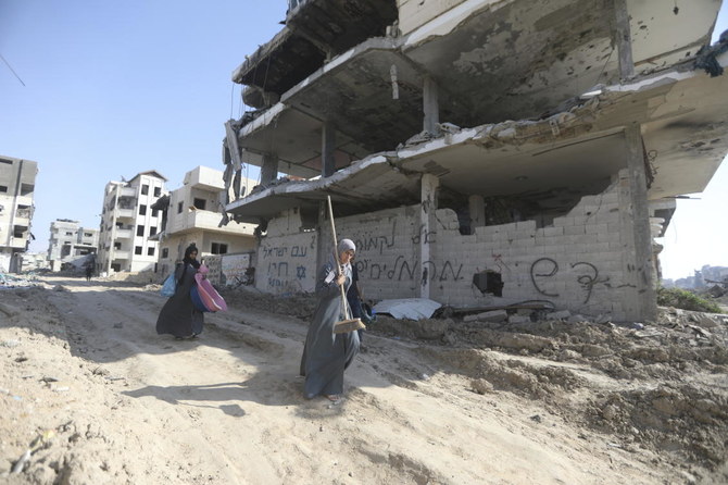 2024年4月7日、ガザ地区のハーン・ユーニスからイスラエル軍撤退後、空爆と地上攻撃によって破壊された瓦礫の中を歩くパレスチナ人。(AP)