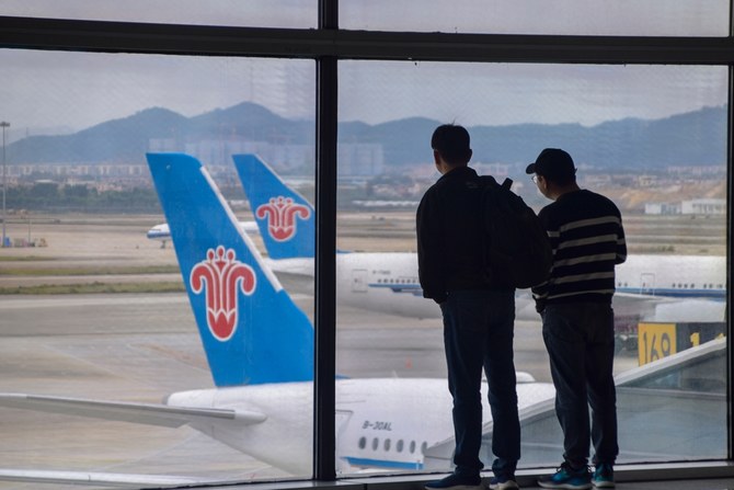 広州白雲国際空港。中国南方航空の航空機を遠くから眺める乗客。シャッターストック 