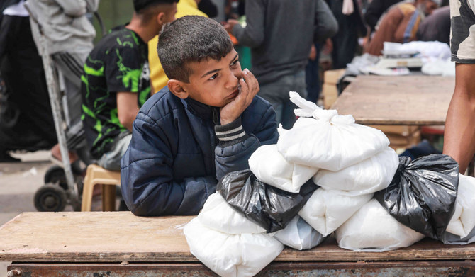 イスラエルと過激派組織ハマスの対立が続く中、2024年4月5日、ガザ地区南部のラファで、イスラム教の聖なる断食月「ラマダン(断食月)」を締めくくるイード・アル・フィトルのお祝いを前に、市場で食料品を売るパレスチナ人の子ども。(AFP=時事通信)