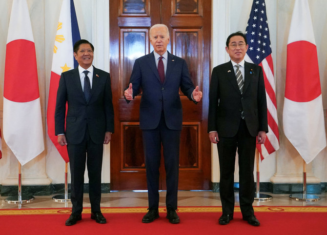 2024年4月11日、ワシントンのホワイトハウスで3カ国首脳会談、フィリピンのフェルディナンド・マルコス・ジュニア大統領と日本の岸田文雄首相に付き添いながら話すジョー・バイデン米大統領。(REUTERS)