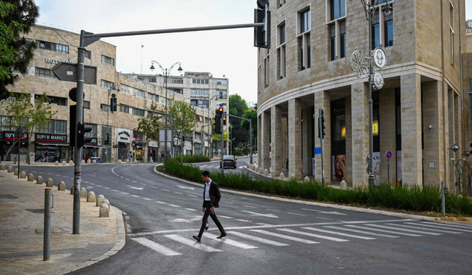 2024年4月14日、誰もいないエルサレムの通りを横切る男性。(AFP＝時事）