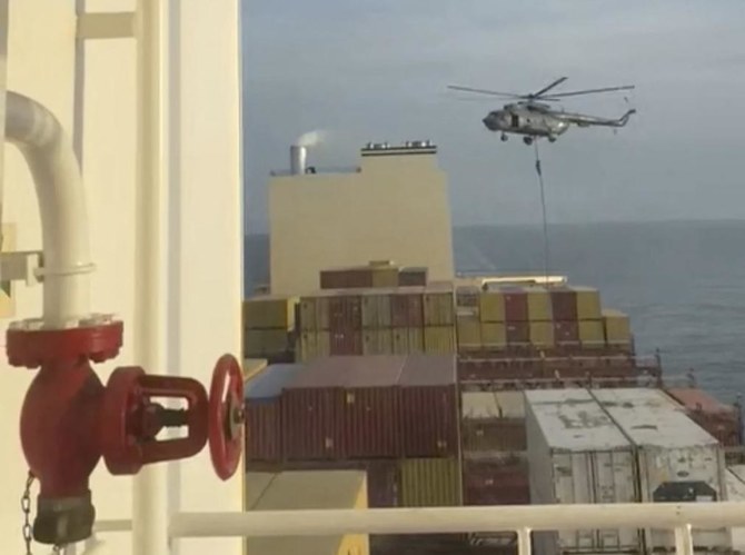 2024年4月13日、MSCアリエスへのヘリコプター突入の際、ロープを滑り降りる職員。(ファイル／ロイター）