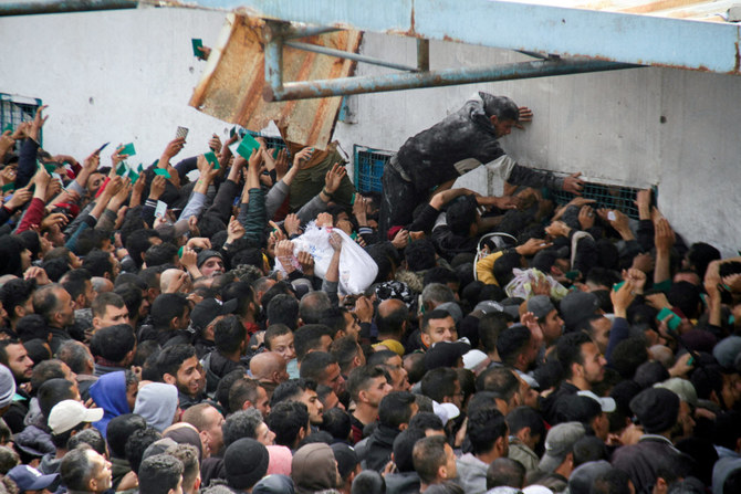 2024年3月18日、イスラエルとハマスの紛争が続く中、ガザ市のUNRWA倉庫の外で援助を受け取ろうと集まるパレスチナ人。(REUTERS/File Photo)