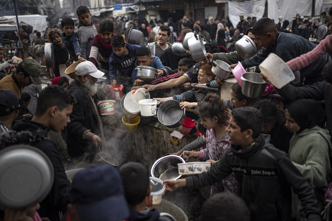 2023年12月21日、イスラエルとハマスの戦いの中、ガザ地区のラファで食事のために並ぶパレスチナ人。(AP Photo/File)
