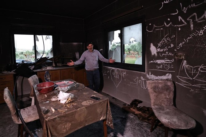 2024年4月17日、ラマッラー近郊のヨルダン川西岸地区アルムガイル村で、イスラエル入植者に襲撃されたパレスチナ人男性が、自宅の台所で身振り手振りを交えている。(AFP＝時事）