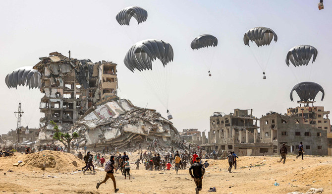 2024年4月23日、イスラエルと過激派組織ハマスの間で紛争が続く中、ガザ地区北部上空に投下された人道支援物資に殺到する人々。(AFP＝時事）