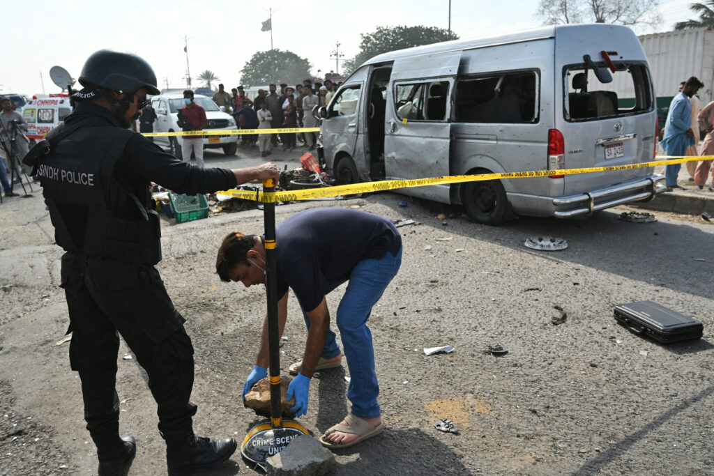 2024年4月19日、カラチで車両が襲撃された現場で封鎖する警察関係者。(AFP＝時事）