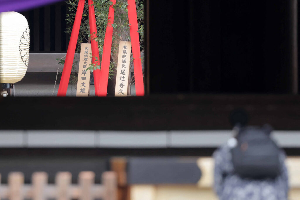 2024年4月21日の春季例大祭で、岸田文雄首相が靖国神社にお供えした「真榊」（左）と共に掲げられている銘板。(AFP)