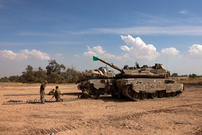 イスラエルとガザ地区の国境に近い陸軍キャンプで、戦車の整備をするイスラエル軍兵士（AFP＝時事通信）