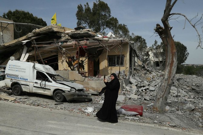 2024年4月25日、レバノン南部のハニン村で、4月23日にイスラエルの空爆で同じ家族の女性2人が死亡したとされる家の前に立つ女性。(AFP＝時事）
