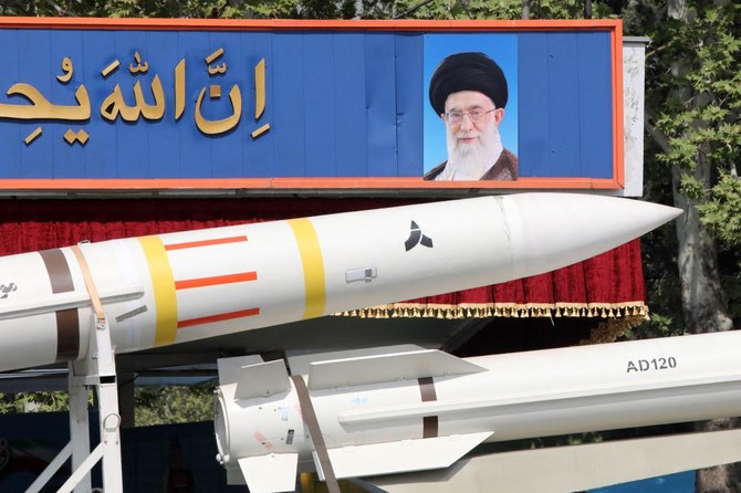 2024年4月17日、首都テヘランで行われた軍事パレードで、最高指導者アヤトラ・アリ・ハメネイ師の肖像画の前を通過するサヤド4-Bミサイルの部品を運ぶイランの軍用トラック。(AFP＝時事）