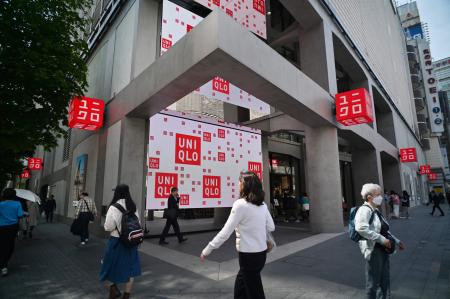 2024年4月11日、東京のファーストリテイリング「ユニクロ」の店舗前を通り過ぎる歩行者。(AFP＝時事通信）