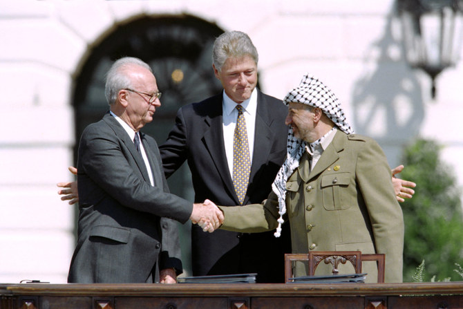 1993年9月13日、オスロ合意調印後、ワシントンDCのホワイトハウスで、パレスチナ指導者ヤセル・アラファト（右）とイスラエル首相イツァーク・ラビン（左）の間に立つビル・クリントン米大統領。(AFP/ファイル)