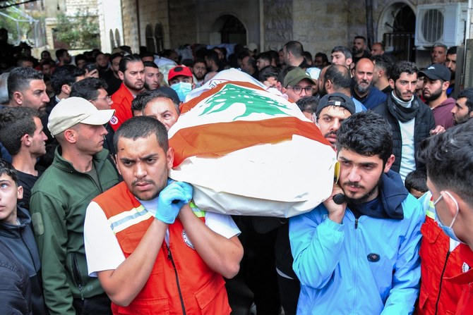 イスラエル軍の空爆による犠牲者の遺体を運ぶ緊急救援隊員（レバノン南部ハバリェ、2024年3月27日撮影）（AFP＝時事