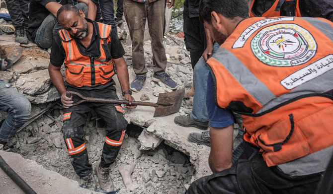 2024年5月11日、イスラエルとハマスの紛争が続く中、ガザ地区中央部のアル・ザウェーダで、イスラエル軍の空爆で破壊された住宅ビルの瓦礫の下敷きになった遺体を確認するパレスチナ人救助隊員。(AFP＝時事）