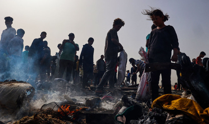 2024年5月27日、イスラエルとパレスチナの過激派組織ハマスとの戦闘が続く中、ラファの国内避難民を収容するキャンプ地区へのイスラエル軍の空爆現場に集まるパレスチナ人。(AFP)